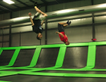Two Guys Flipping on Trampolines